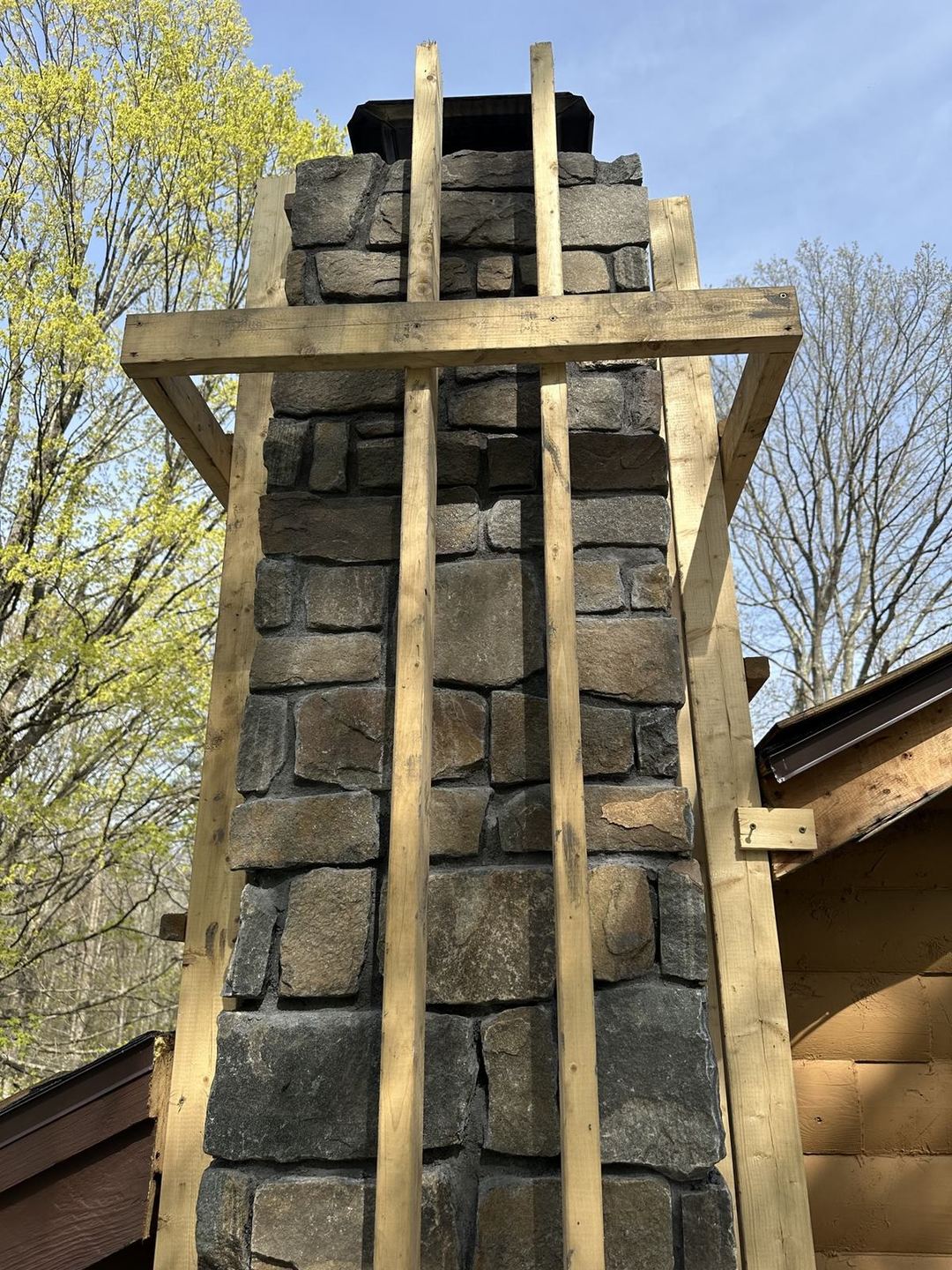 Stone veneer partially installed on the chimney, in progress