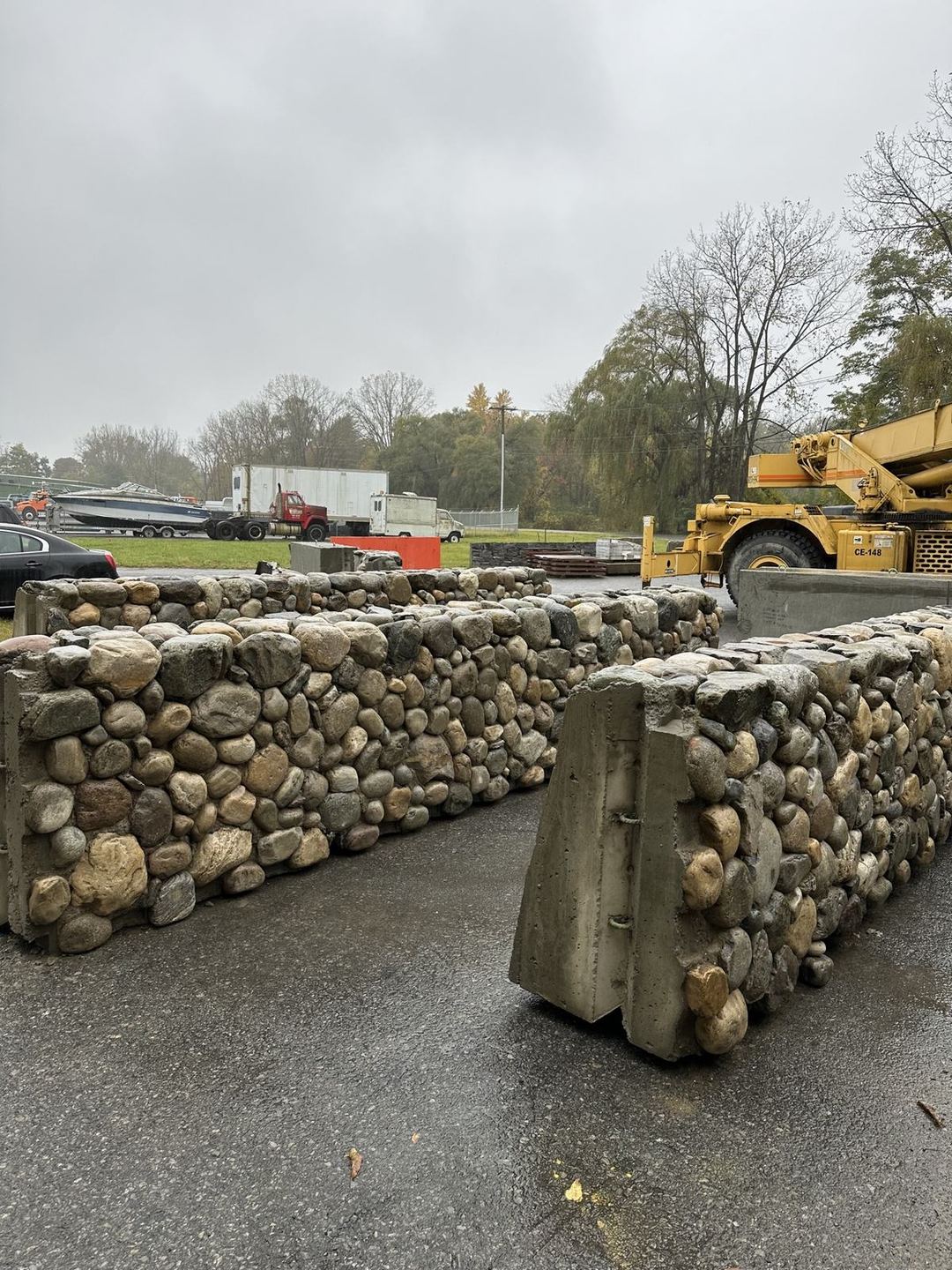 Stone wall panels staged outdoors with a crane nearby